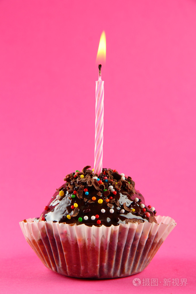 美味的生日蛋糕的蜡烛,粉红色的背景上