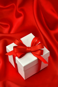 红丝带在丝绸白色礼品盒
