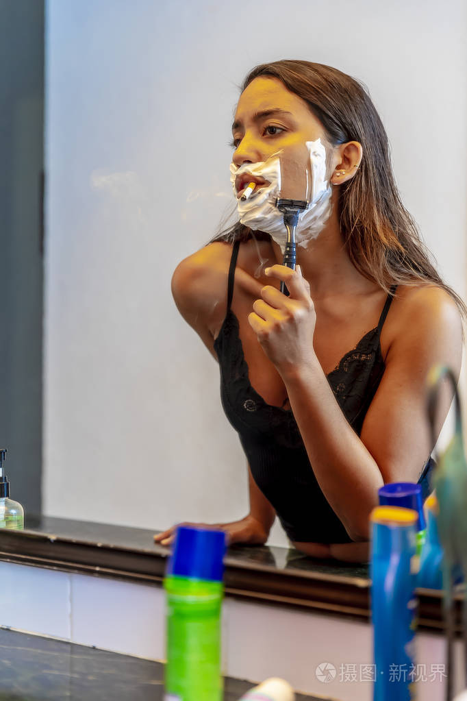 一个美丽的西班牙裔黑发模特在抽雪茄时剃须