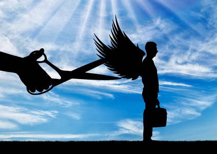 大手剪刀的剪影打算修剪一个人的翅膀.商业中的卑鄙与背叛概念照片