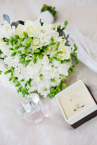 结婚日。新娘花束和白色金戒指