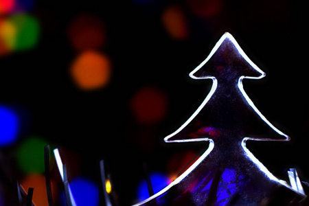 圣诞树和抽象的模糊灯光背景。蓝色, 紫色, 橙色的颜色。庆祝概念
