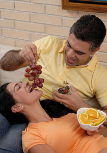 在客厅里吃水果的中期成人夫妻