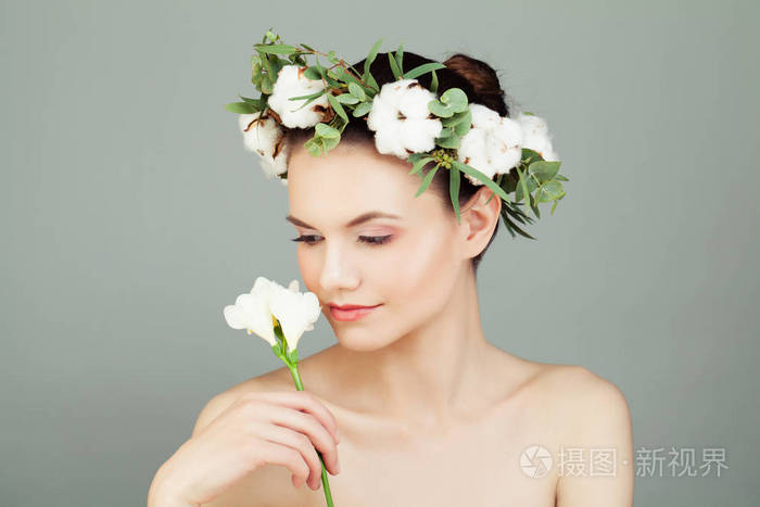 水疗模特女子手捧白花.可爱的女性脸, 健康的皮肤和白色的棉花花