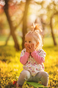 可爱开朗的小女孩, 金发女郎, 漫步在阳光灿烂的花园里