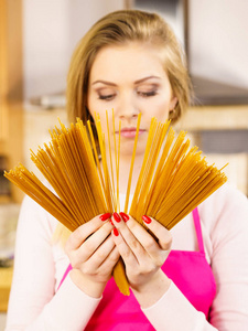 女人拿着长面条通心粉准备煮意大利面。健康食品概念