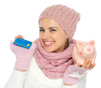 微笑中持有的信用卡和 pi 的针织的冬季服装的女人