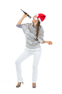 快乐的女人在圣诞老人帽子唱歌的麦克风