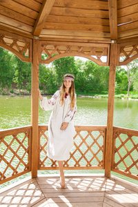 美丽的乌克兰妇女身着刺绣在一个木制夏天 altanka 湖