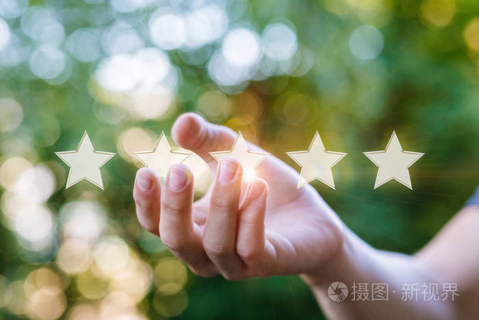 手在模糊的背景上显示星星评级概念