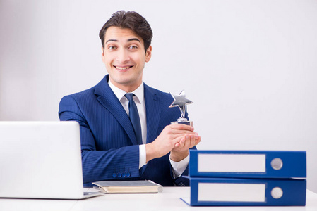 年轻英俊的生意人员工在办公室工作在办公桌上照片