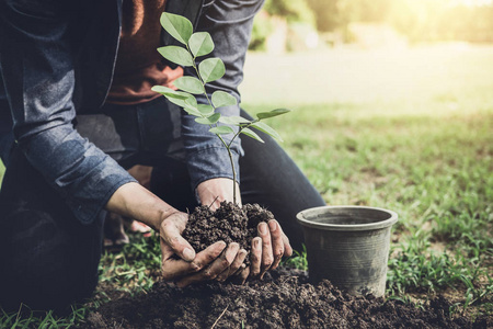 年轻人在花园里植树作为地球日, 拯救世界概念自然环境和生态