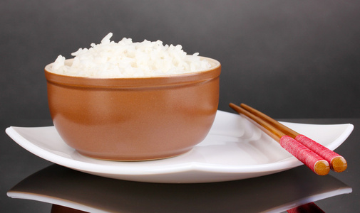 碗的米饭和筷子上灰色背景板上
