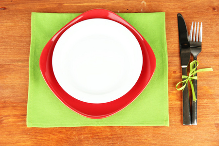 空的红色和白色板木桌上的刀和叉的特写