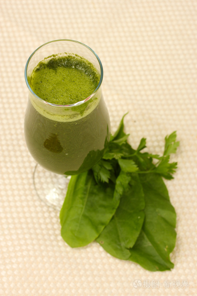 在coctail 玻璃光背景上的绿色蔬菜汁