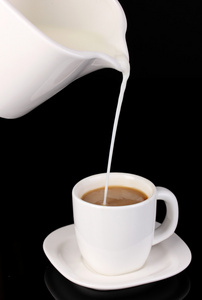 微妙的奶油倒入杯咖啡黑隔离