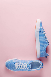 蓝色条纹运动鞋在粉红色柔和的背景