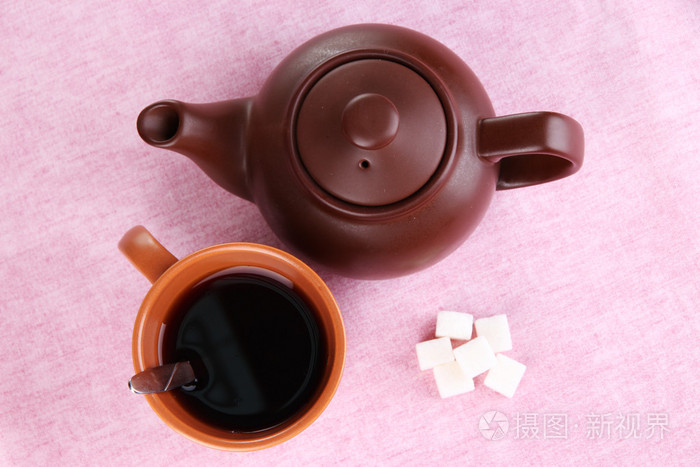 杯茶，茶壶上粉色桌布的顶视图