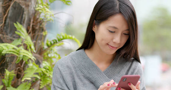 在户外街道使用移动电话的妇女