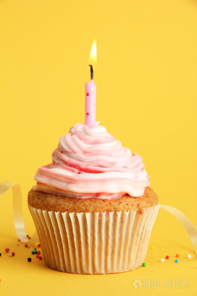 美味的生日蛋糕的蜡烛,在黄色背景上