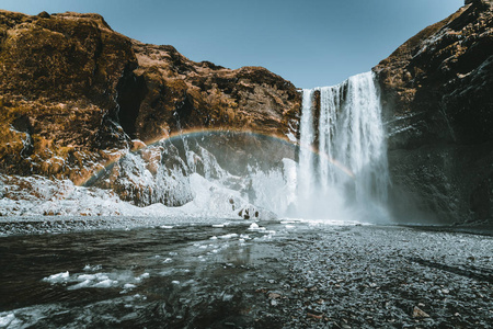 Skogafoss 瀑布在冰岛与彩虹在晴朗的天与蓝色的天空