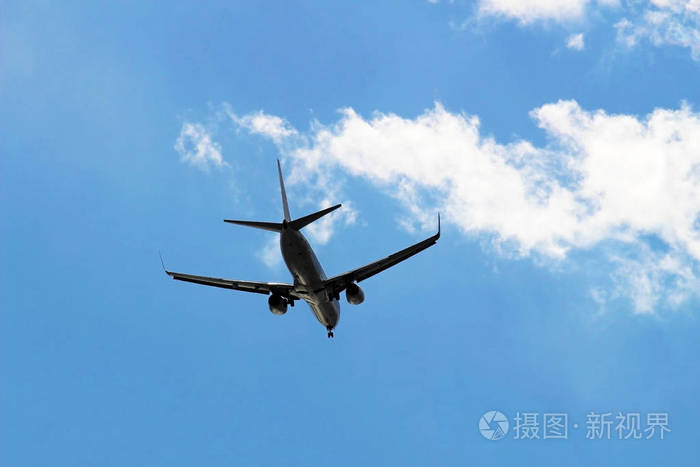 在蓝天下飞翔的飞机的背面
