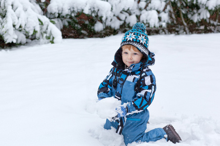 可爱的小孩男孩在冬季一天玩雪