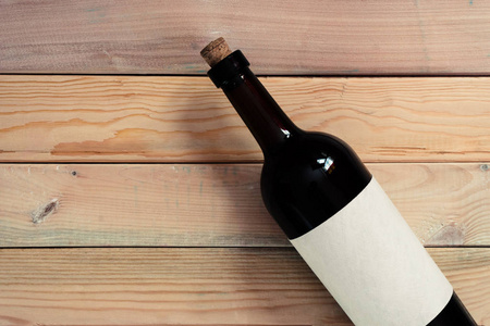 黑瓶红酒放在一张木桌上。美丽的背景