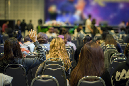 演讲者在舞台上以观众的后方观点在会议或研讨会会议,商业和教育概念