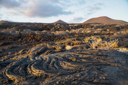 太阳在熔岩场上与岩石和熔岩流在日落期间, La 拉斯汀, El 耶罗, 加那利群岛, 西班牙