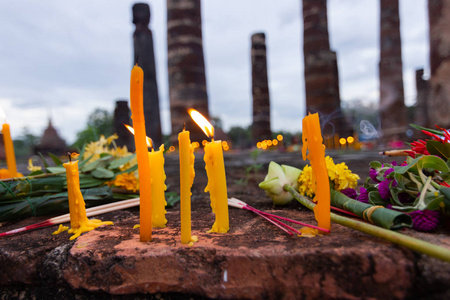 在泰国宗教的重要日子, 在水泥寺庙上燃烧蜡烛佛教符号照片