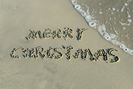 在美丽的沙滩上手写的圣诞快乐
