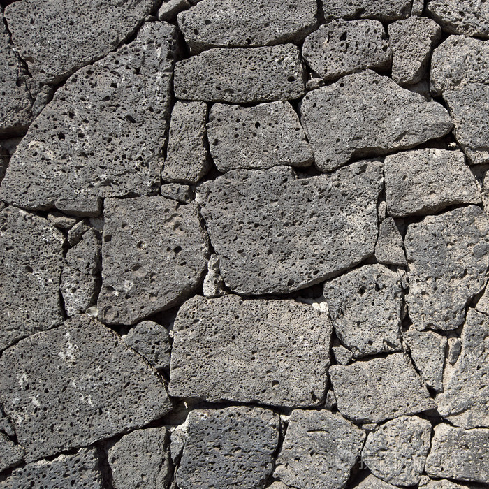 纹理的黑色火山岩石墙