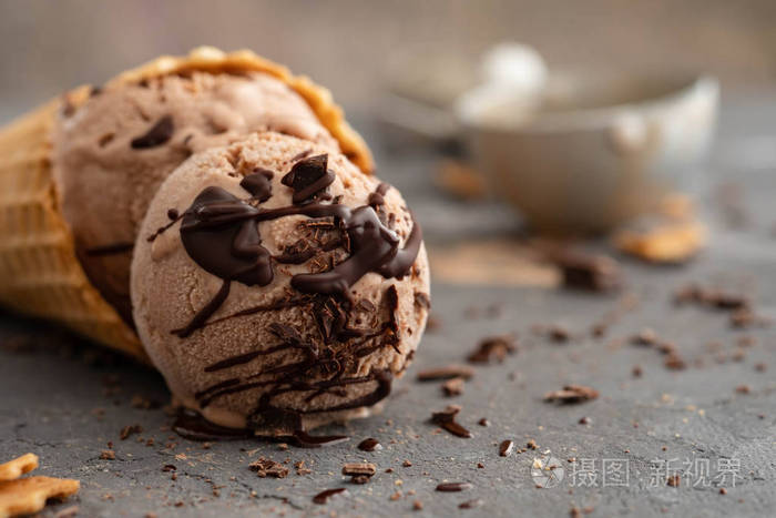 自制的巧克力冰淇淋在华夫饼锥, 用勺子冰淇淋, 可可和黑巧克力片.