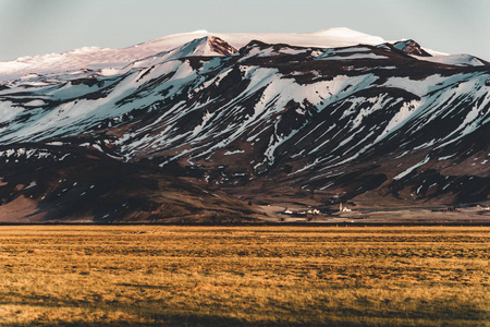 冰岛典型的山冬天场面以草在前景和大山在背景上