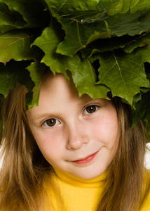 小女孩用绿色枫叶叶头上，