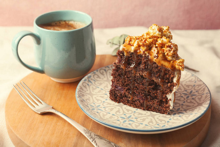 一块美味的自制蛋糕与焦糖酱和杯咖啡木板