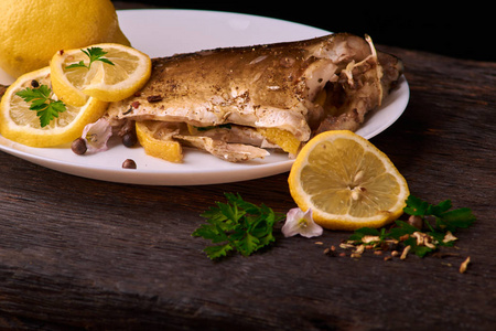 美味的烤鲤鱼鱼, 柠檬片, 香料, 新鲜的迷迭香在烘烤床单上, 从上面查看