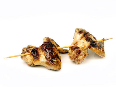 鸡翅煎在一个挂在一个白色的背景串串上的烤架上隔离