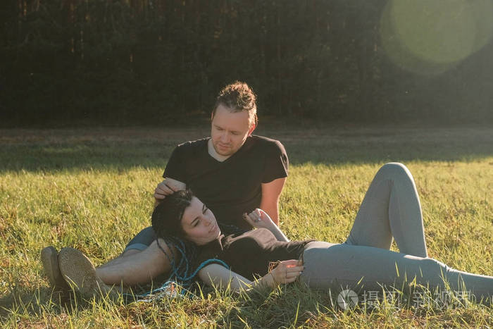 情侣们在公园里放松躺在草地上聊天