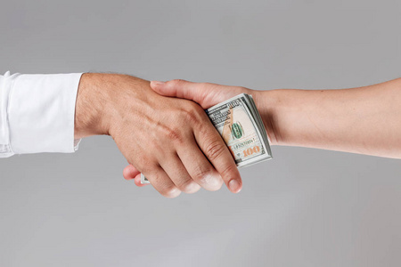 商人手里拿着钱商人手里拿着钱进行握手.
