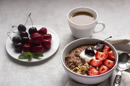 巧克力麦片粥顶着草莓, 樱桃, 核桃和巧克力片。早餐的概念。复制空间