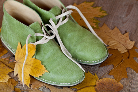 绿色皮革靴子和黄色树叶