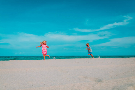 快乐的孩子男孩和女孩在海滩上奔跑