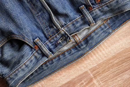 关闭前蓝色牛仔裤质地和细节的木质背景