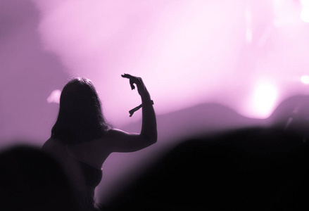 粉红色过滤, 后视图的人群与手臂伸展在音乐会上。舞台灯