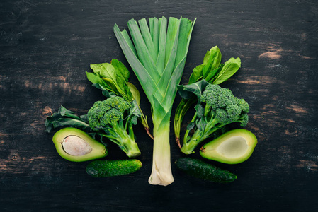 新鲜的绿色蔬菜和水果的木质背景。健康食品。顶部视图。复制空间