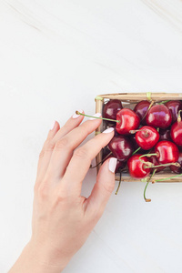 创意顶部的新鲜成熟樱桃在一个小柳条篮与复制空间隔绝白色背景最小的风格。夏天乐趣和健康饮食的概念。文本或食品设计模板