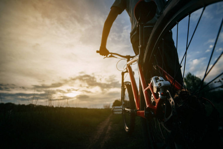 在日落的乡间小路上骑自行车的人站着