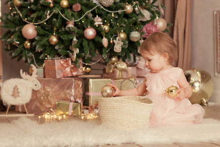 圣诞背景下滑稽快乐的孩子的肖像。小女孩玩新年球